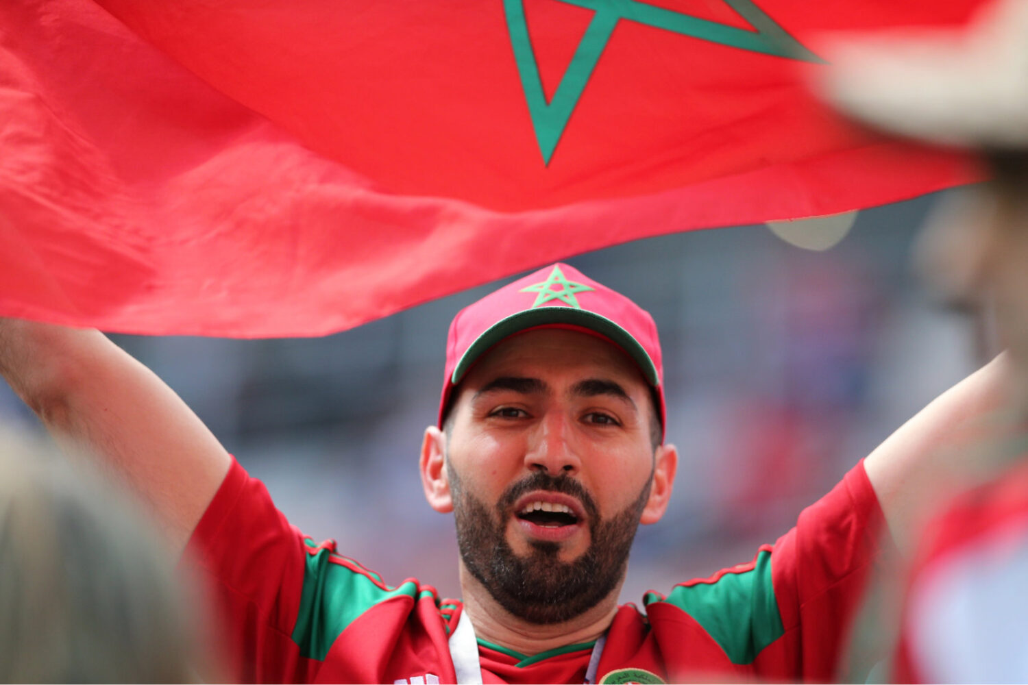 Man celebrating with Moroccan flag at event.